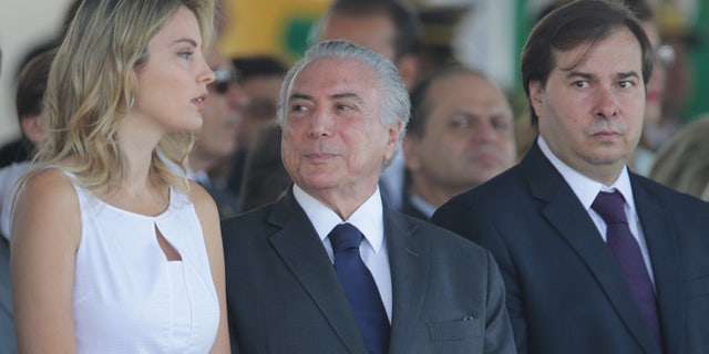Brazil's President Michel Temer, center, talks with his wife Marcela Temer, during an Independence Day military parade in Brasilia, Brazil, Wednesday, Sept. 7, 2016. Pictured right is Lower House Speaker Rodrigo Maia. (AP Photo/Eraldo Peres)
