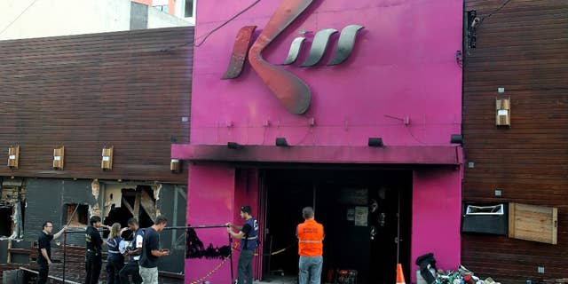 FILE - In this Jan. 27, 2013 file photo, police investigators inspect the entrance of the Kiss nightclub after a fire inside the club in Santa Maria city, Rio Grande do Sul state, Brazil. A court on Wednesday, June 3, 2015 convicted and sentenced to one year in jail two of the eight firefighters on trial for the nightclub fire that killed more than 200 people. The firefighters had been charged with negligence and with falsifying public documents related to the club's fire permit. (AP Photo/Nabor Goulart, File)