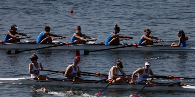 Aug. 4, 2015: Teams of rowers from Italy, top, and the U.S., bottom, practice for the 2015 World Rowing Junior Championships on Rodrigo de Freitas lake in Rio de Janeiro, Brazil. (AP Photo/Silvia Izquierdo)
