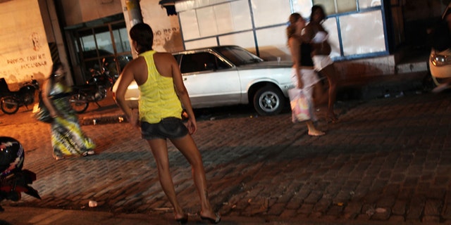 RIO DE JANEIRO, BRAZIL - DECEMBER 11: Female prostitutes walk the streets of the red light district, Vila Mimosa, following a fashion show with clothes designed by sex workers on December 11, 2009 in Rio de Janeiro, Brazil. The fashion show, which is a government sponsored project to give female prostitutes other career choices, displayed dozens of new designs on both models and three fellow prostitutes. The Association of the Residents and Friends of Vila Mimosa teaches the women skills in sewing and design. Out of the 105 woman to enroll in the fashion design program 65 have now found jobs in other professions besides working in the sex industry. (Photo by Spencer Platt/Getty Images)