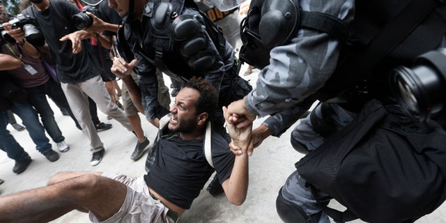 A man is carried away during a protest next to the Maracana Stadium in Rio de Janeiro, on Dec. 16, 2013.