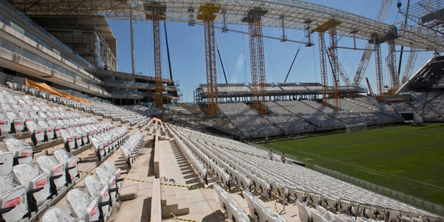 Men work at the Itaquerao, the stadium that will host the World Cup opener in less than three months in Sao Paulo, Brazil, Saturday, March 15, 2014. The Itaquerao was one of the six stadiums that were supposed to be finished by the end of 2013, but a crane collapse that killed two workers in November caused significant delays to the venue where Brazil will play Croatia on June 12. The stadium is not expected to be ready before mid-April. (AP Photo/Andre Penner)
