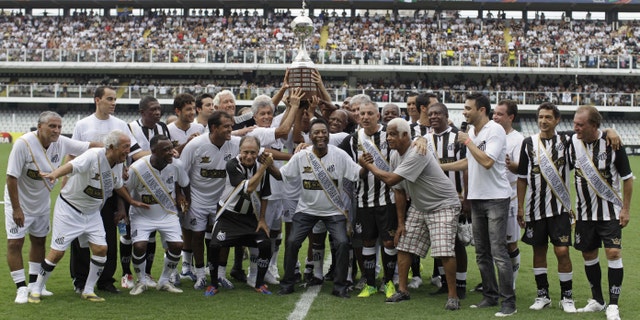 Pele, center, with other former Santos soccer players hold the Libertadores trophy during the team's centennial celebration in Santos, Brazil, Saturday, April 14, 2012. Santos, the Brazilian club that ruled soccer with "The king," Pelé in the 1960s turned 100 with a rich history to show for it, including many major titles and notable victories that have made the club one of the most successful in football.  (AP Photo/Nelson Antoine)