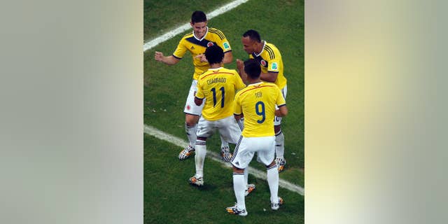 Colombia's James Rodriguez, left, dances as he celebrates with his teammates after scoring his side's second goal during the World Cup round of 16 soccer match between Colombia and Uruguay at the Maracana Stadium in Rio de Janeiro, Brazil, Saturday, June 28, 2014. (AP Photo/Fabrizio Bensch, Pool)