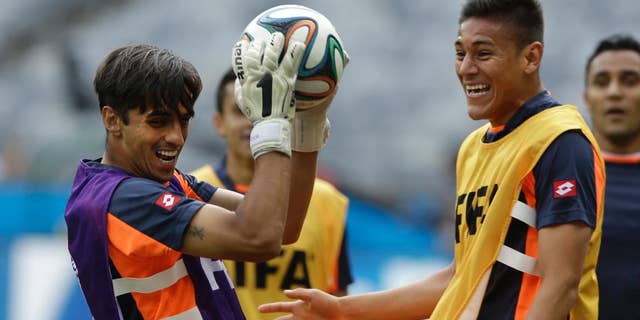 Costa Rica's captain and attacking player Bryan Ruiz, left, catches the ball whilst playing as a goalkeeper during an official training session the day before the group D World Cup soccer match between Costa Rica and England at the Mineirao Stadium in Belo Horizonte, Brazil, Monday, June 23, 2014. (AP Photo/Matt Dunham)