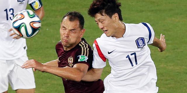 Russia's Sergei Ignashevich, left, and South Korea's Lee Chung-yong (17) go for a header during the group H World Cup soccer match between Russia and South Korea at the Arena Pantanal in Cuiaba, Brazil, Tuesday, June 17, 2014. (AP Photo/Thanassis Stavrakis)