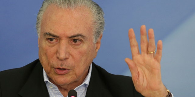 Brazil's President Michel Temer speaks to the press about proposed anti-corruption legislation in Brasilia, Brazil, Sunday, Nov. 27, 2016. Many Brazilians are concerned the legislation to toughen prosecution of corruption might perversely offer amnesty to politicians who had previously engaged in the practice. (AP Photo/Eraldo Peres)