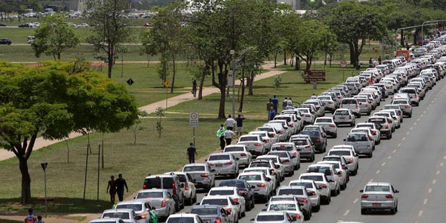Taxi drivers protest against the online transportation service Uber, in Brasilia, Brazil, Tuesday, Nov. 8, 2016. More than 1 thousand taxi drivers, many in their vehicles, staged a protest in front of Congress demanding that it prohibits the U.S. based company from operating in Latin America's largest nation. (AP Photo/Eraldo Peres)