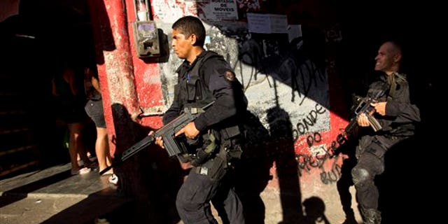 April 4, 2012: Police officers belonging to the BOPE (Special Police Operations Battalion) unit, patrol the Rocinha slum in Rio de Janeiro, Brazil.