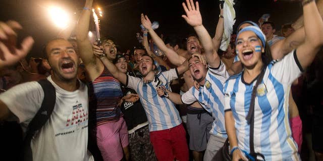 Soccer fans of the Argentina national soccer team celebrate their team's victory during a live broadcast of the soccer World Cup match between Argentina and the Netherlands, inside the FIFA Fan Fest area on Copacabana beach, in Rio de Janeiro, Brazil, Wednesday, July 9, 2014. Argentina made it to the World Cup final with a 4-2 shootout win over the Netherlands after the game finished in a 0-0 stalemate. (AP Photo/Silvia Izquierdo)