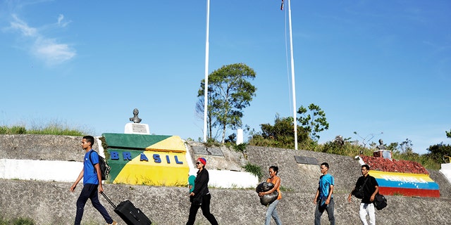 Venezuelans walk across the border into the Brazilian city of Pacaraima