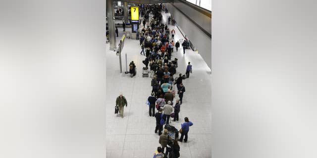 People queue in the luggage hall of Terminal 5 at Heathrow Airport in London, Friday, Dec. 12, 2014. London's airspace was closed today due to what authorities say was a computer failure at one of Britain's two air traffic control centres. Britain's national air traffic body says the computer problem that touched off troubles in the system has been fixed and it is in the process of returning to normal operations. (AP Photo/Matt Dunham)