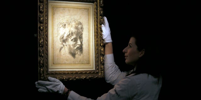 Nov. 30, 2012: A Sotheby's employee adjusts a drawing by Raffaello Sanzio, otherwise known as Raphael called 'Head of an Apostle', a Renaissance masterwork, during a press viewing in London.