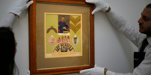Nov. 9, 2012: Employees from Sotheby's auction house adjust the original Sir Peter Blake 1967 collage for the iconic Beatles album Sgt Pepper's Lonely Hearts Club Band, which will be sold at auction, during a press viewing in London.