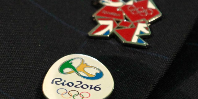 Rio 2016 and London 2012 Olympics pins are seen on the jacket lapel of Mayor of London Boris Johnson during a join press conference in London with the Mayor of Rio de Janeiro, Eduardo Paes to outline how London is working with the Brazilian city to ensure a smooth handover when the London 2012 Olympic Games come to an end this weekend, Friday, Aug. 10, 2012. Rio de Janeiro is to host the 2016 Olympic Games. (AP Photo/Sang Tan)
