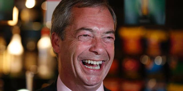 FILE - In this Friday, May 23, 2014 file photo, Nigel Farage, leader of Britain's United Kingdom Independence Party (UKIP) smiles at a pub in South Benfleet, England. British politician Nigel Farage has defended a hotel that insisted a breast-feeding mother cover up, suggesting women might "sit in the corner" while they feed their babies. Farage told LBC radio Friday Dec. 5, 2014 that women should breast-feed "in a way that is not openly ostentatious." (AP Photo/Lefteris Pitarakis, File)