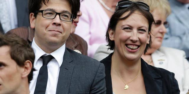 FILE - This is a Saturday, July 7, 2012 file photo of British comedian Michael McIntyre, left, and comedian Miranda Hart, as they watch Serena Williams of the United States face Agnieszka Radwanska of Poland in the women's final match at the All England Lawn Tennis Championships at Wimbledon, England. An image of the top of Micheal McIntyre's head has Britons debating the decline of privacy in an age of surveillance. On Wednesday July 15, 2015 the National Police Air Service, which operates camera-equipped helicopters, tweeted an image of a man with a mop of dark hair, asking if people could recognize "a certain energetic funny man." (AP Photo/Kirsty Wigglesworth, File)