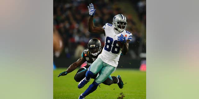 Dallas Cowboys wide receiver Dez Bryant (88) is defended by Jacksonville Jaguars strong safety Johnathan Cyprien (37) during the first half of an NFL football game at Wembley Stadium, London, Sunday, Nov. 9, 2014. (AP Photo/Matt Dunham)