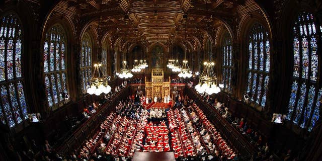 FILE - This is a Wednesday June 4, 2014 file photo of Britain's Queen Elizabeth, rear centre, as she delivers her speech in the House of Lords, during the State Opening of Parliament at the Palace of Westminster in London . An annual speech, read by the monarch at the ceremonial State Opening of Parliament, the Queen's Speech is written by the government and outlines its legislative program. Winning the vote that follows is crucial to the survival of any government. This year's Queen's Speech will be May 27, when either Conservative leader David Cameron or Labour’s Ed Miliband will unveil his government's plans. (Suzanne Plunkett/Pool Photo via AP, File)