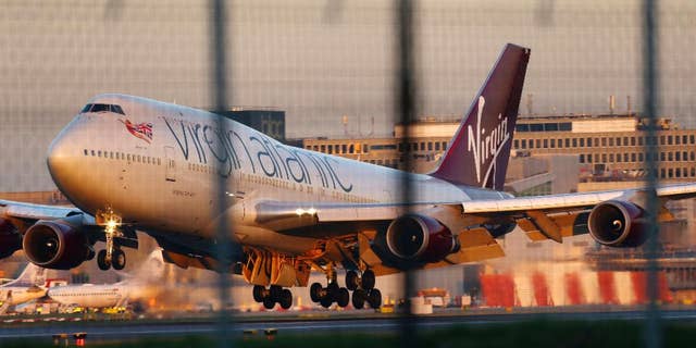 A Virgin Atlantic Boeing passenger jet performs an emergency landing at Gatwick Airport after developing a landing gear fault, London, Monday, Dec. 29 2014. The airline says the plane undertook "a non-standard landing procedure" because of "a technical issue with one of the landing gears." (AP Photo/PA, Gareth Fuller) UNITED KINGDOM OUT, NO SALES, NO ARCHIVE