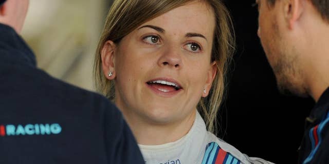 FILE - In this Friday, July 4, 2014 file photo, Scottish Suzie Wolff of Williams, the first woman to take part in a Formula 1 race weekend in 22 years, talks to mechanics in the garage before the first practice session at the British Grand Prix at Silverstone, England. Wolff has been promoted to official test driver for Williams for the 2015 Formula One season, increasing her chances of becoming the first female racer on the grid since 1976, it was announced on Friday, Nov. 28, 2014. (AP Photo/Rui Vieira, File)
