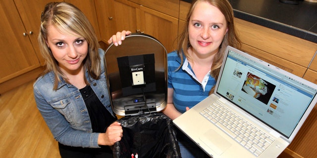 June 8, 2011: Newcastle University students Julia Miebach, left, and Anja Thieme, right, with the Bincam and a laptop showing its Facebook page. Five households have signed up for a program announced Wednesday that puts photographs of every item placed in a garbage can on Facebook, to raise consciousness about recycling efforts.