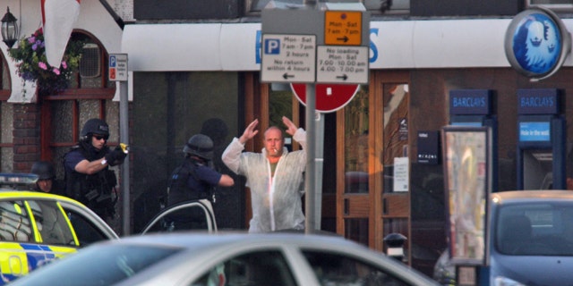 June 28: Armed police cover a man as he leaves a Barclays bank with his hands up in Ashford, England. Armed officers deployed to the scene of a possible hostage situation at a bank near London's Heathrow Airport. (AP)