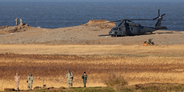 Jan. 8, 2014: The wreckage of a US Military Air Force Pave Hawk helicopter, partially obscured in front of helicopter right, lies on the ground in Salthouse, England, after the helicopter crashed late Tuesday killing all four crew members aboard.