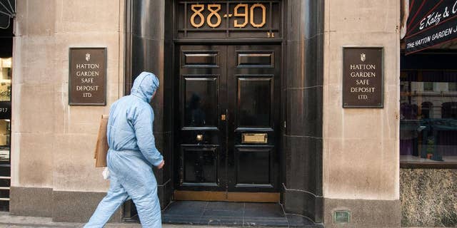 FILE - In this Tuesday, April 7, 2015 file photo, Police forensics officer enter the Hatton Garden Safe Deposit company in London. More than 200 British police swooped down on suspected jewel thieves Tuesday, May 19, 2015, making arrests in the notorious Hatton Garden heist that took place in London over the Easter weekend. Scotland Yard said seven British men, ranging in age from 48 to 76, are being questioned in a London police station after the morning raids. The men were arrested in north London and in Kent, southeast of the city. (Dominic Lipinski/PA via AP, file) UNITED KINGDOM OUT - NO SALES - NO ARCHIVES