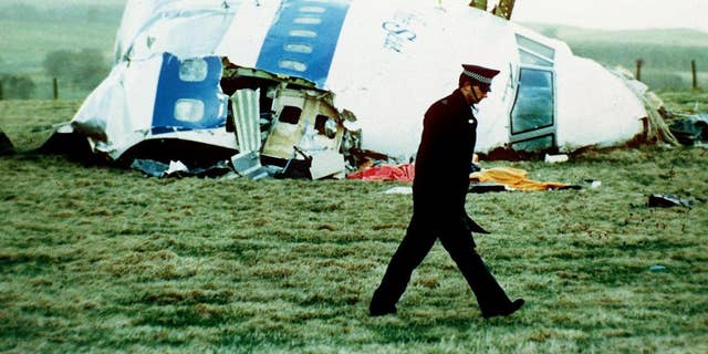 a police officer walks by the nose of Pan Am flight 103 in Lockerbie, Scotland, where it lay after a bomb aboard exploded, killing a total of 270 people.
