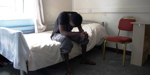 In this photo provided by Kent County Council, a young male refugee sits on a bed at reception centre in the county of Kent in southeast England in early September 2015. The Afghan, Eritrean and Sudanese refugee boys at the centre will be moved again and this time it’s a happy occasion: After months of hardship traversing continents, the teenage refugees are finally on the way to English homes where they can settle down for a long dreamed-of life in Europe. (Kent County Council via AP)