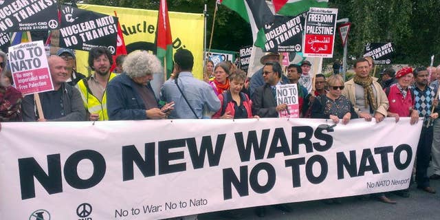 Supporters take part in the 'No to NATO' protest march in Newport, south Wales, Saturday, Aug. 30, 2014. Around 1,000 protesters have marched through the streets of Newport ahead of next week's NATO summit. More than 150 heads of state and ministers will attend the two-day event at Newport's Celtic Manor Resort. The event will be "uncharted territory" for police - while Wales' First Minister Carwyn Jones has said it will be "momentous" in his country's history. However, its presence in the principality - and the UK - has been met with strong opposition from a number of anti-war groups as well as left-wing organizations. A large crowd gathered outside Newport Crown Court at around midday before going on a march through the Welsh city. As well as strong Welsh contingent, protesters came from as far as Washington, Belgium, France and Ireland. (AP Photo/Benjamin Wright, PA Wire) UNITED KINGDOM OUT - NO SALES - NO ARCHIVES