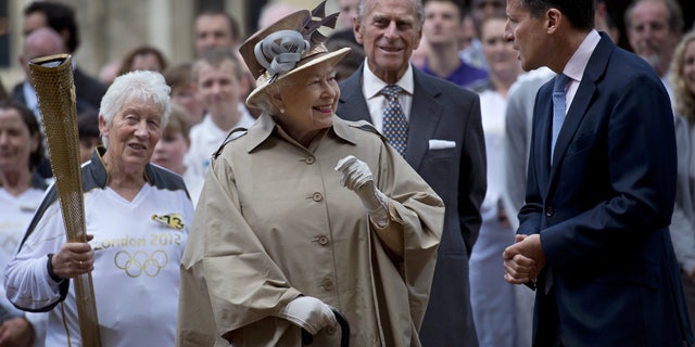 July 10, 2012: Britain's Queen Elizabeth II, second left, her husband Prince Philip, second right, London 2012 Chairman Sebastian Coe, right, and seventy four year-old Olympic torch bearer Gina Macgregor, left, at Windsor Castle, Windsor, England.