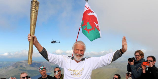 May 29, 2012: In this file photo made available by LOCOG, Sir Chris Bonington holds the Olympic Flame on the top of Mount Snowdon in Wales during the Olympic Torch Relay.