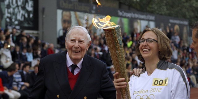July 10, 2012: The Olympic Flame is passed between Sir Roger Bannister and Oxford doctoral student Nicola Byrom on the running track at Iffley Road Stadium in Oxford, England.