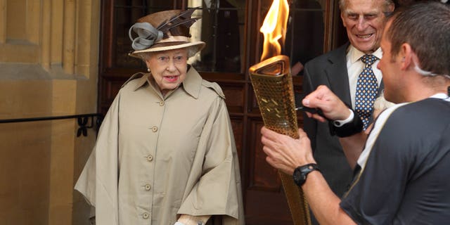 July 10, 2012: Britain's Queen Elizabeth II and Prince Philip look at the Olympic Flame at Windsor Castle, Windsor, England.