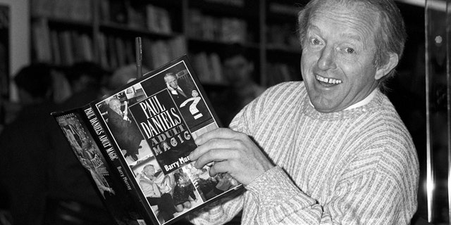 This is a Dec. 2, 1989 file photo of British magician Paul Daniels as he holds with a copy of his book 'Adult Magic' at Whiteleys book shop in London.