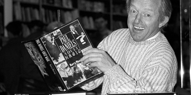 This is a Dec. 2, 1989 file photo of British magician Paul Daniels as he holds with a copy of his book 'Adult Magic' at Whiteleys book shop in London.