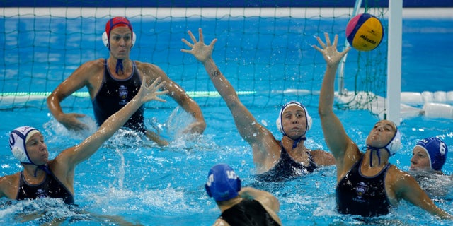 May 3, 2012: Gabriella Szucs, of Hungary, No 5, at bottom, shoots and scores a goal against the US during their international Women's Water Polo event, preliminary round, at the London 2012 Olympic water polo pool in London.
