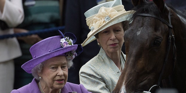 FILE - June 20, 2013: Britain's Queen Elizabeth II, left, with her daughter Princess Anne greet her horse Estimate, who won the Gold Cup horse race on the third day of the Royal Ascot horse race meeting, traditionally known as Ladies Day, in Ascot, England. (AP Photo/Alastair Grant, file)