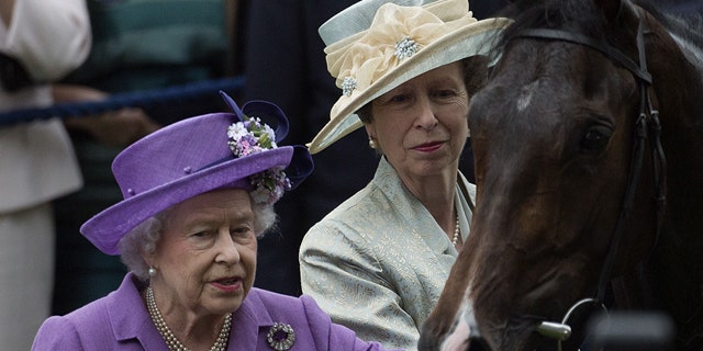 FILE - June 20, 2013: Britain's Queen Elizabeth II, left, with her daughter Princess Anne greet her horse Estimate, who won the Gold Cup horse race on the third day of the Royal Ascot horse race meeting, traditionally known as Ladies Day, in Ascot, England. (AP Photo/Alastair Grant, file)