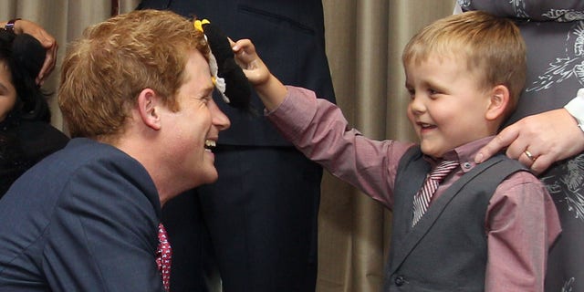 Sept. 3, 2012: Britain's Prince Harry talks to Alex Logan, right,  who puts a toy penguin against his head, as he attends the WellChild awards ceremony InterContinental Park Lane Hotel, London.