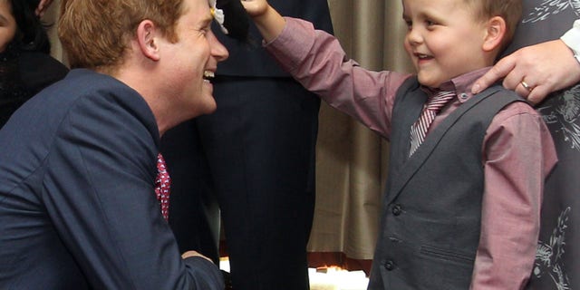 Sept. 3, 2012: Britain's Prince Harry talks to Alex Logan, right, who puts a toy penguin against his head, as he attends the WellChild awards ceremony InterContinental Park Lane Hotel, London.