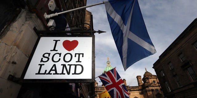 FILE - In this Thursday, Feb. 13, 2014, file photo a Scottish flag and a Union flag fly outside a Scottish memorabilia shop in Edinburgh, Scotland. (AP Photo/Scott Heppell, File)