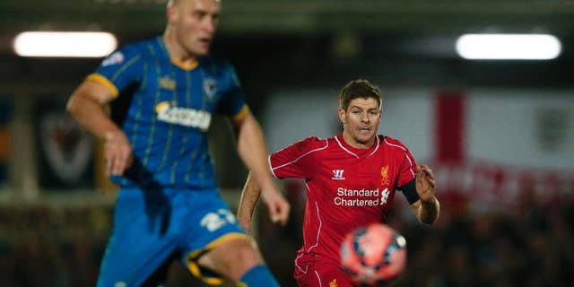 Liverpool's Steven Gerrard, right watches as =AFC Wimbledon's Adam Barratt passes back to his goalkeeper during their English FA Cup third round soccer match between AFC Wimbledon and Liverpool in Kingston, London, Monday, Jan. 5, 2015 . (AP Photo/Alastair Grant)