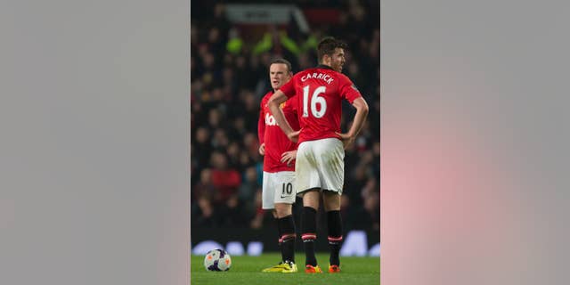 Manchester United's Wayne Rooney, left, and Michael Carrick wait for play to begin after a second goal by Manchester City's Edin Dzeko, out of frame. during their English Premier League soccer match at Old Trafford Stadium, Manchester, England, Tuesday March 25, 2014. (AP Photo/Jon Super)