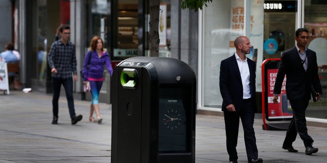 Aug. 12, 2012 - People walk past a trash bin in central London. Officials say an advertising firm must immediately stop using its network of high-tech trash cans, like this one, to track people walking through London's financial district.
