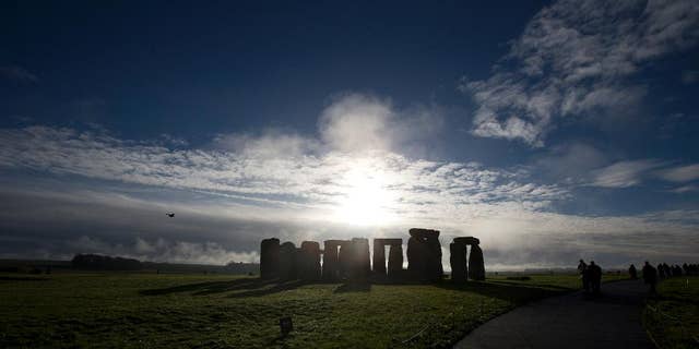 FILE - In this Tuesday, Dec. 17, 2013 file photo, visitors take photographs of the world heritage site of Stonehenge, England.