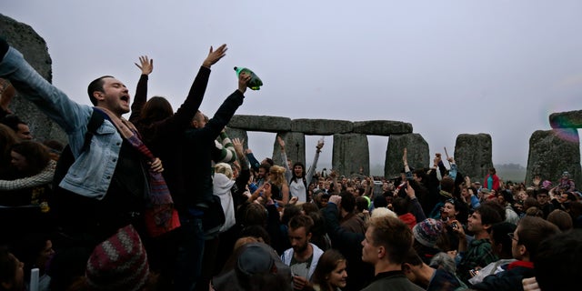 June 21, 2013 - People dance and raise their hands in celebration during the summer solstice shortly after 04.52 am at the prehistoric Stonehenge monument, near Salisbury, England, Friday. Following an annual all-night party, thousands of new agers and neo-pagans waited at the ancient stone circle Stonehenge for the sun to come up, but cloudy skies prevented them. They danced and whooped in delight .