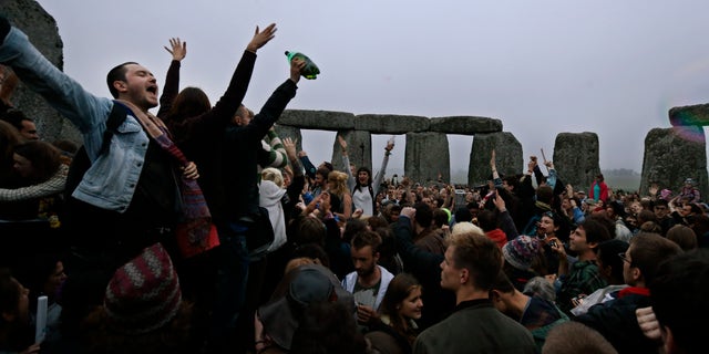 June 21, 2013 - People dance and raise their hands in celebration during the summer solstice shortly after 04.52 am at the prehistoric Stonehenge monument, near Salisbury, England, Friday. Following an annual all-night party, thousands of new agers and neo-pagans waited at the ancient stone circle Stonehenge for the sun to come up, but cloudy skies prevented them. They danced and whooped in delight .